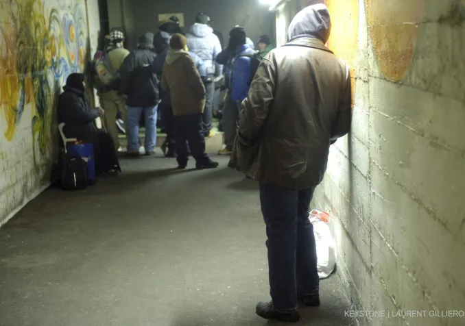 Des SDF attendent l'ouverture du centre d'urgence hivernal dans un abri de la PC à la Vallée de la jeunesse à Lausanne. KEYSTONE/Laurent Gillieron