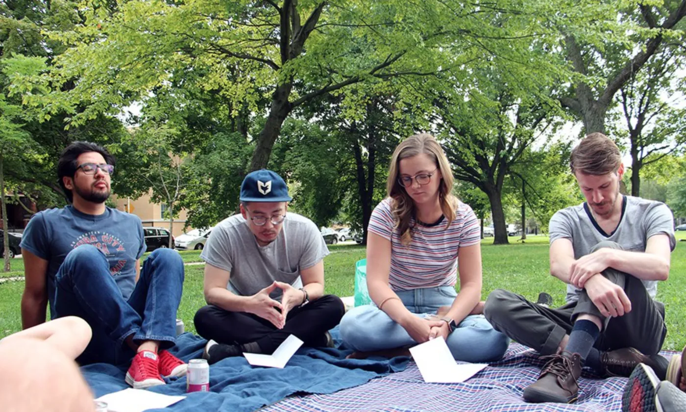 Le pasteur Tim Kim (au centre), des membres et invités de l'Eglise Root & Branch Church se rassemblent pour un service d'Eglise à table, le 25 août 2019, au Palmer Square Park à Chicago. RNS