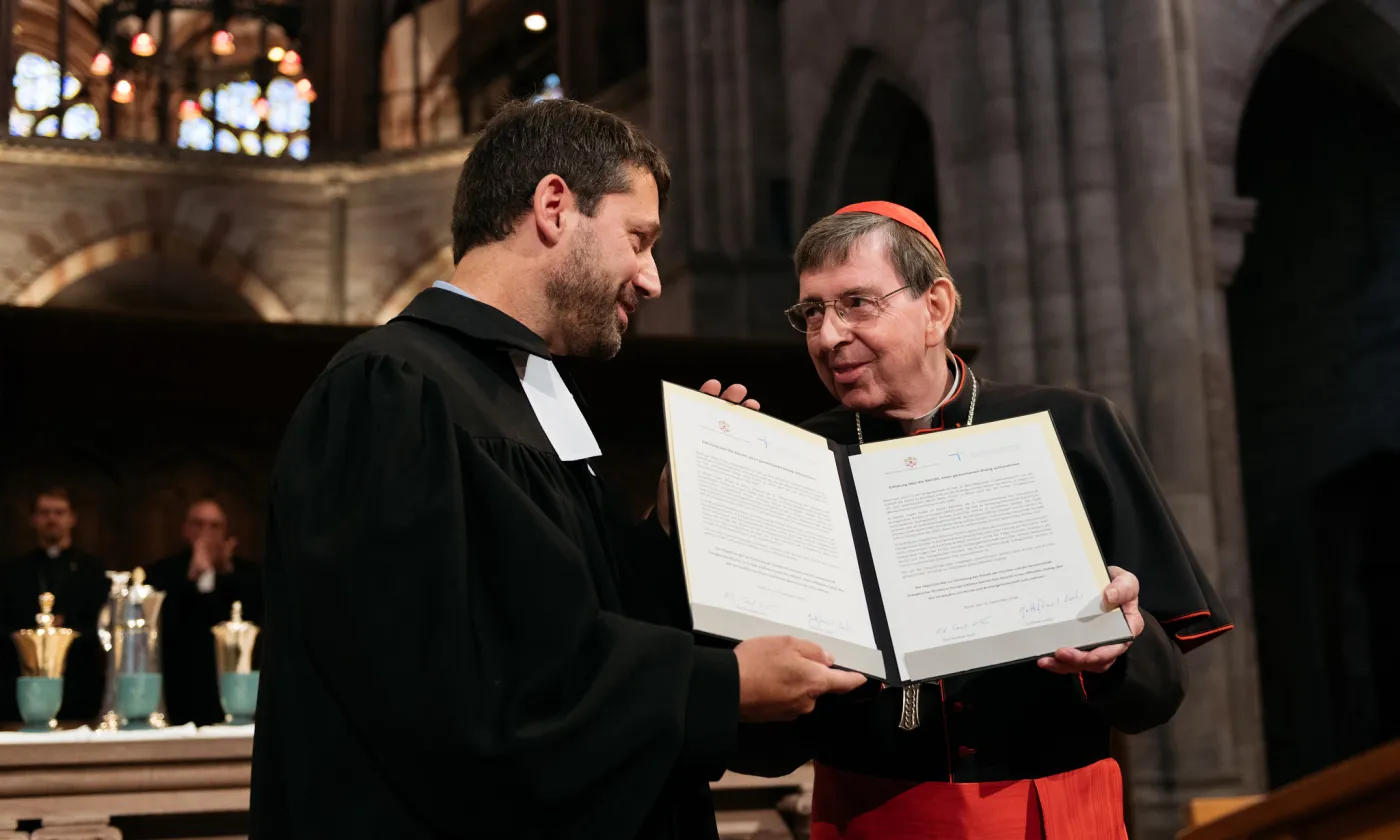 Gottfried Locher et le cardinal Kurt Koch tenant la déclaration d'intention proposant de commencer un dialogue officiel entre les protestants d'Europe et le Vatican. Elle a été signée à la cathédrale de Bâle le 16 septembre dernier. © FEPS/Olivier Hochstrasser